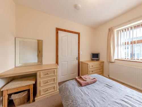a bedroom with a bed and a mirror and a window at 2 Bed in Aberystwyth TWLCT in Llanfihangel-y-creuddyn