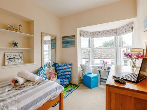 a bedroom with a bed and a desk with a laptop at 3 Bed in Charmouth DC121 in Charmouth