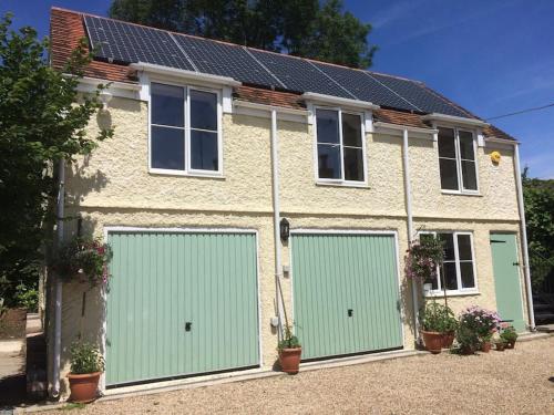 a house with two garage doors in front of it at Bed@Byways, Holton in Wincanton