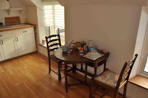 una mesa en una cocina con 2 sillas y una mesa en Bed@Byways, Holton, en Wincanton