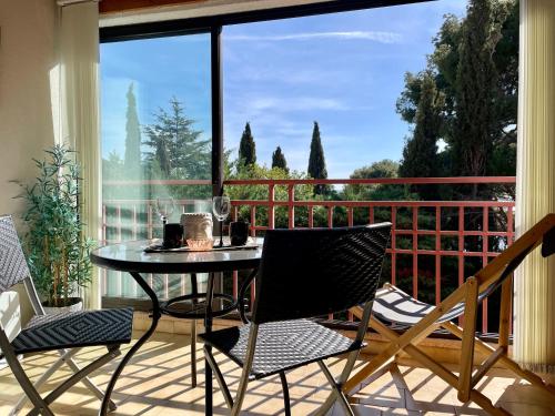 un patio avec une table et des chaises sur un balcon dans l'établissement Joli appartement en bordure de mer à 15 minutes du port de Bandol, à Bandol