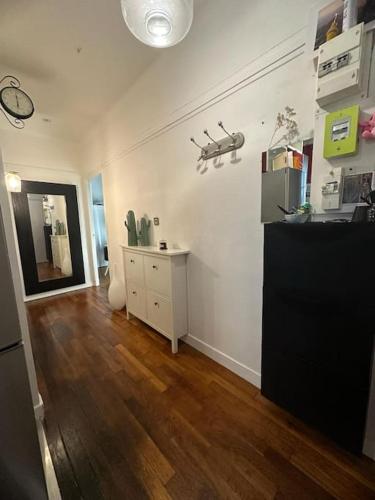 een woonkamer met een houten vloer en witte muren bij Appartement de charme- Proche JO Paris 24 in Colombes