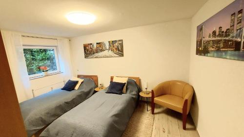 1 dormitorio con 2 camas y 1 silla en Apartment de luxe 73 qm mit 3 Zimmer und Terrasse, en Einhausen