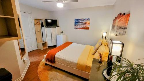 a bedroom with a bed and a television in it at Kokomo INN Bed and Breakfast Ottawa-Gatineau's Only Tropical Riverfront B&B on the National Capital Cycling Pathway Route Verte #1 - for Adults Only - Chambre d'hôtes tropical aux berges des Outaouais BnB #17542O in Ottawa