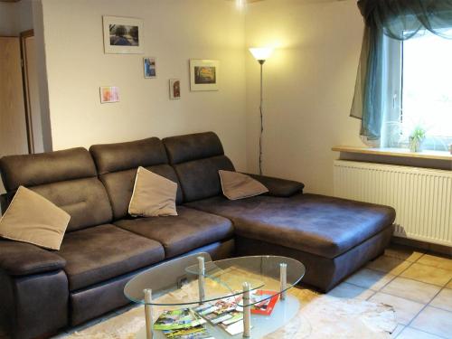 ein Wohnzimmer mit einem braunen Sofa und einem Tisch in der Unterkunft Am Kahlenberg in Marsberg