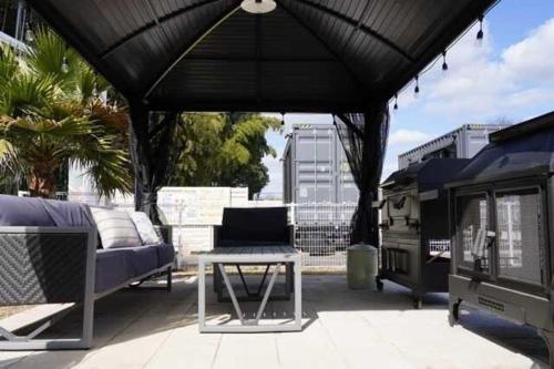 un patio con sofá y mesa bajo un dosel negro en SHONAN BASE - Vacation STAY 23273v en Abiko
