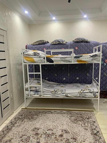 a bedroom with a bunk bed and a carpet at Altan Hostel Osh in Osh