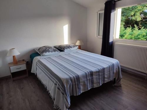 a bedroom with a bed and a window at Gîte avec piscine - 4 personnes - Pays Cathare in Cuxac-Cabardès