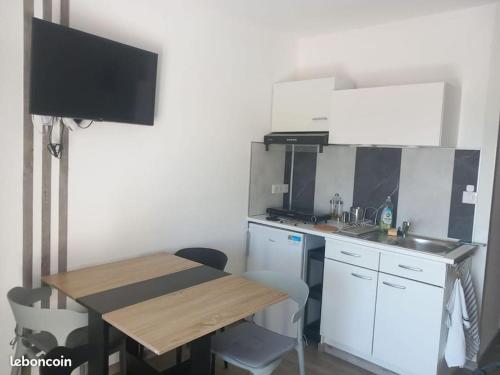 a small kitchen with a table and a sink at Gîte avec piscine - 4 personnes - Pays Cathare in Cuxac-Cabardès