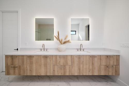 a bathroom with two sinks and two mirrors at LUXE - Tulum House - New Build - Heated Pool in Scottsdale