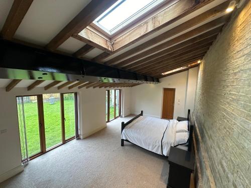 sypialnia z łóżkiem w pokoju z oknami w obiekcie Roe Hollow w mieście Old Hurst