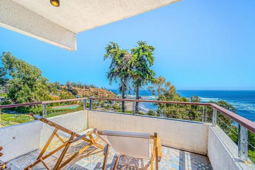 a balcony with two chairs and the ocean at Refugio Azul 3D con Vistas in Puchuncaví