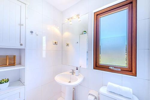a white bathroom with a sink and a window at Refugio Azul 3D con Vistas in Puchuncaví