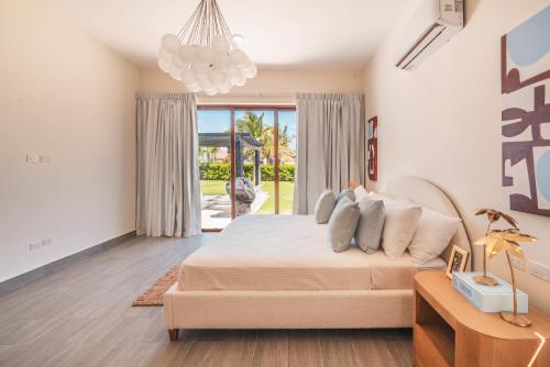 プンタ・カナにあるTropical villa with picuzzi at Green Village BCAの大きなベッドとシャンデリアのある寝室