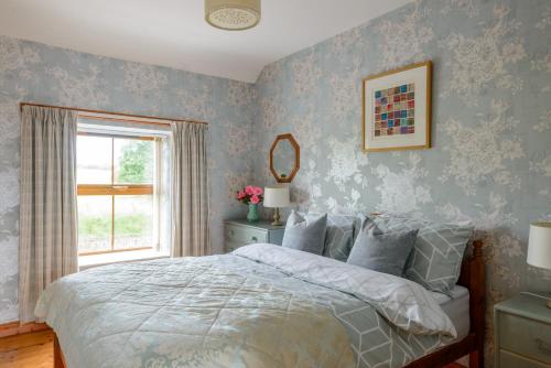 a bedroom with a bed with blue wallpaper at Grove Fort Self Catering Farmhouse in Finnis