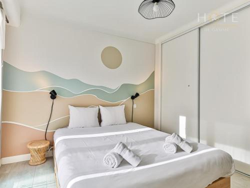 1 dormitorio con 1 cama grande y toallas. en Appartement cocooning proche centre ville et gare en Les Sables-dʼOlonne