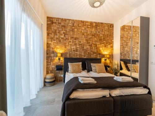een slaapkamer met een groot bed en een bakstenen muur bij Water villa with its own jetty near Harderwijk in Zeewolde