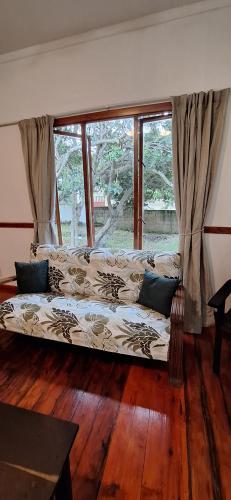 a couch in a living room with a large window at Serenity, Ponta do Ouro in Ponta do Ouro