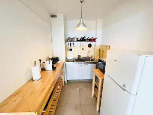Il comprend une cuisine équipée d'un comptoir en bois et d'un réfrigérateur. dans l'établissement Studio Cosy-Vue Mer Panoramique Exceptionnelle, à Bandol