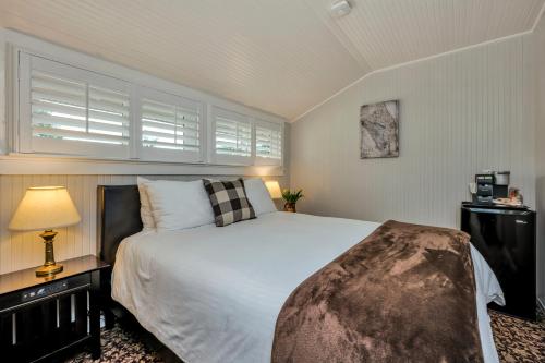 a bedroom with a white bed and a window at Calistoga Wine Way Inn in Calistoga