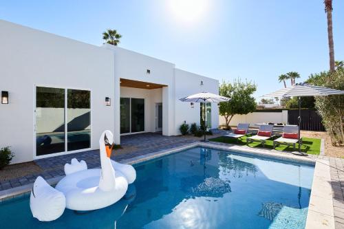 a swimming pool with swans in front of a house at Monroe - Brand-New Remodel - Backyard Oasis in Phoenix