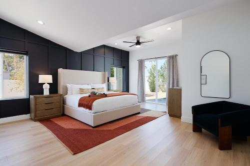 a bedroom with a white bed and a black wall at Monroe - Brand-New Remodel - Backyard Oasis in Phoenix