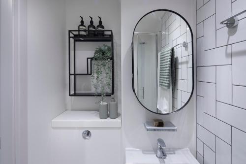 a bathroom with a mirror and a sink at Keel House refurbished Studios in Edinburgh