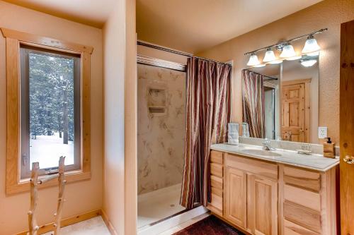 a bathroom with a sink and a shower and a mirror at Serene Mountain Cabin Nestled Amongst the Pines - Alpenhaus in Fairplay