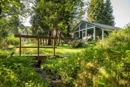 una casa en medio de un campo con gente en ella en Nettes Ferienhaus in Ruhla mit Garten, Grill und Sauna, en Ruhla