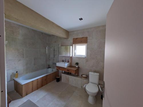 une salle de bain avec une baignoire, des toilettes et un lavabo dans l'établissement Terre de Sienne, à Saint-Clair