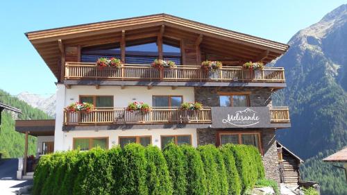 un edificio con un balcón con flores. en Ferienwohnung für 4 Personen ca 54 qm in Sölden, Tirol Skigebiet Sölden, en Sölden