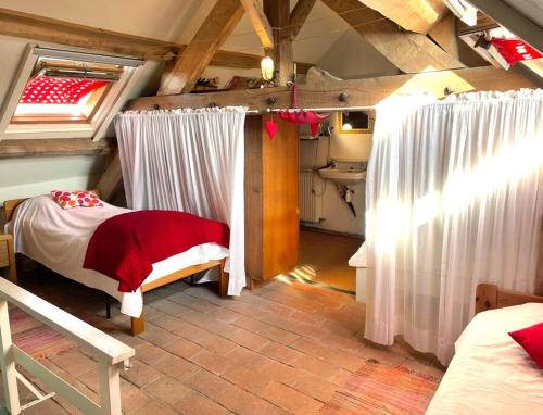 - une chambre mansardée avec un lit et des rideaux dans l'établissement Landelijk familiehuis in Bourgondië, à Mary