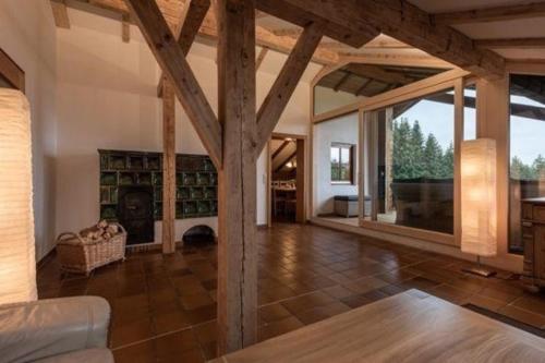a large living room with a fireplace and wooden beams at Luxuschalet - altes Bauernhaus mit private Spa in Regen