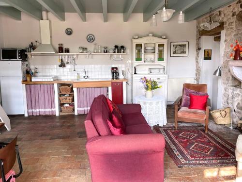 un salon avec un canapé rose et une cuisine dans l'établissement Landelijk familiehuis in Bourgondië, à Mary