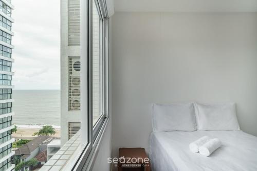 a bedroom with a bed and a view of the ocean at Apto Vista Mar cond. c/ piscina e churrasq VCE1102 in Piçarras