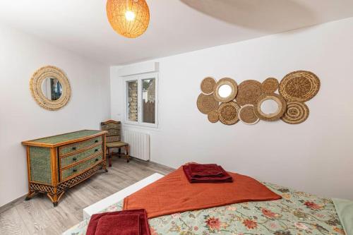 een slaapkamer met een bed, een dressoir en een spiegel bij Le Gîte de la Melonnerie in Hardencourt-Cocherel