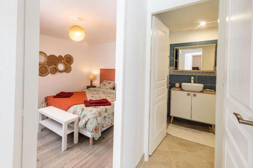 Schlafzimmer mit einem Bett, einem Waschbecken und einem Spiegel in der Unterkunft Le Gîte de la Melonnerie in Hardencourt-Cocherel