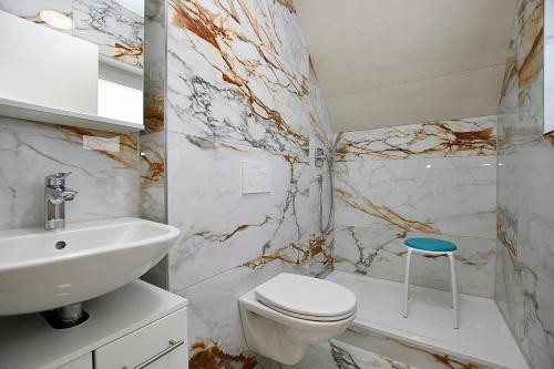 a bathroom with a white toilet and a sink at City-Hotel Zuffenhausen in Stuttgart