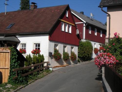 a red and white house with flowers on the side of a street at Ferienhaus "Lena" in Presseck