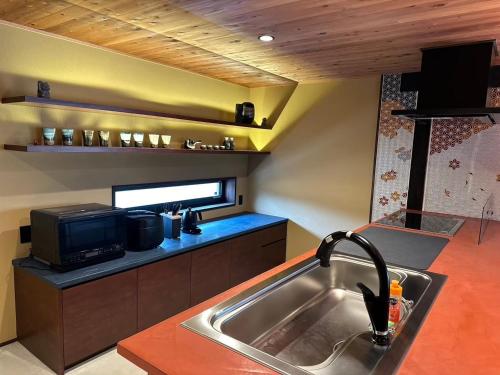 cocina con fregadero y microondas en Tonegun - House - Vacation STAY 16434, en Sudagai