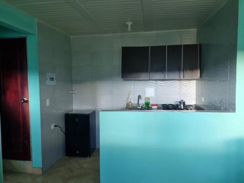 a kitchen with black cabinets and a white refrigerator at Hospedaje San Alberto 201-Ráquira in Ráquira