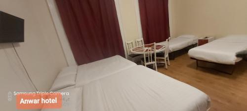 a hospital room with two beds and a table at Anwar House in London