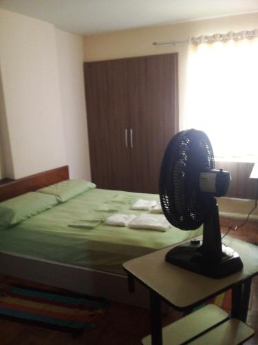 Habitación con 1 cama y ventilador en una mesa. en Conforto e Localização, en Recife