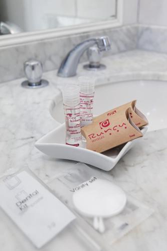a bathroom sink with two tubes of toothpaste on it at Hotel Boutique Runcu Miraflores in Lima