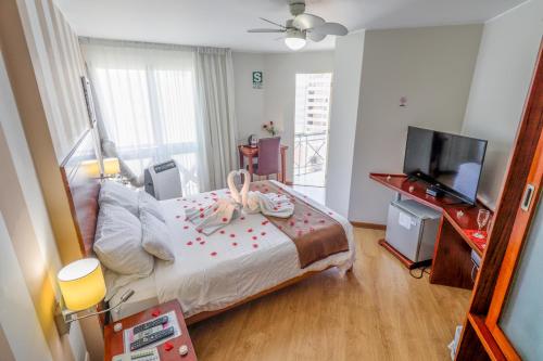 a bedroom with a bed and a flat screen tv at Hotel Boutique Runcu Miraflores in Lima