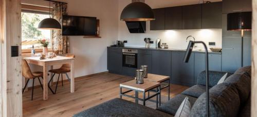 een keuken en een woonkamer met een bank en een tafel bij Exklusive Ferienwohnung mit eigener Sauna - b53578 in Regen