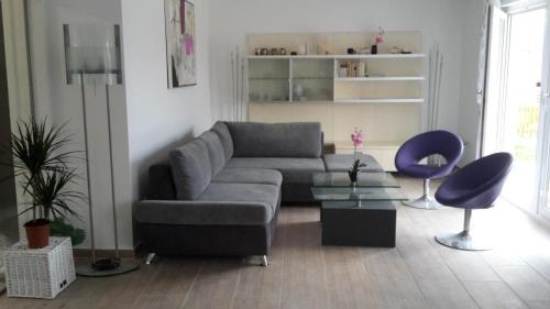 a living room with a gray couch and a blue chair at Neues Ferienhaus in Sankt Margarethen Im Lungau mit Großer Terrasse in Sankt Margarethen im Lungau