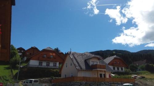 a group of houses on a hill with a blue sky at Neues Ferienhaus in Sankt Margarethen Im Lungau mit Großer Terrasse in Sankt Margarethen im Lungau