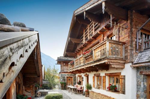 ein Holzgebäude mit einem Balkon und einem Tisch in der Unterkunft Ferienhaus für zehn Erwachsene und zwei Kinder mit Sauna und Kamin in Flachau