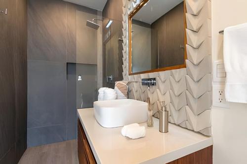 a bathroom with a sink and a mirror at Condo Moots 101 with private pool & rooftop yoga in Tulum